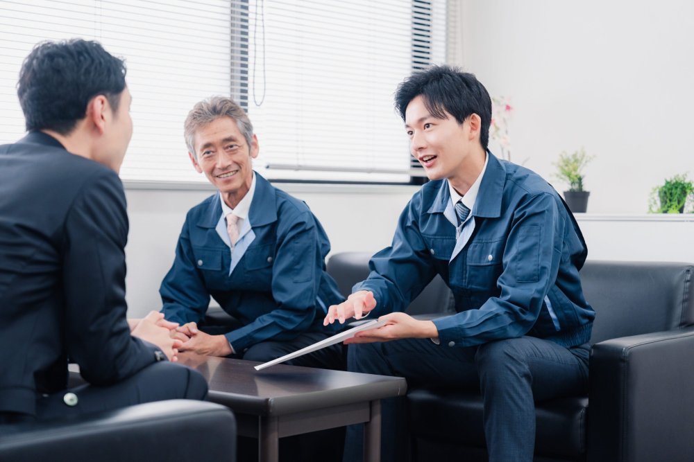 ソファで打ち合わせる三人