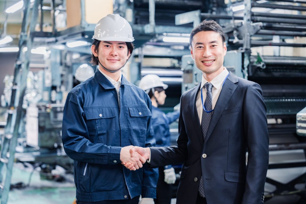 工場で握手する二人