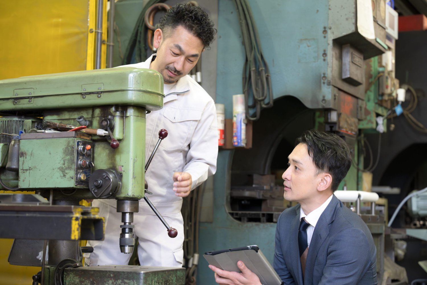 機械の前で打ち合わせる作業員